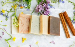 Natural handmade soap bars with organic medicinal plants, cinnamon spice and flowers.Homemade beauty products with natural essential oils from plants and flowers, top view closeup photo
