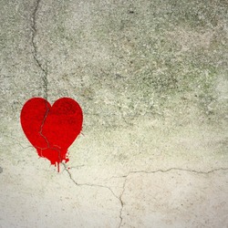 Cracked red heart on concrete wall