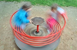 Two children in a red carousel spinning round