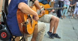 street performers with guitar, with audience in the background