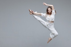 Beautiful young modern dancer or fitness dancer on a white isolated background