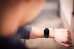 Hand wearing elegant smartwatch with clock app