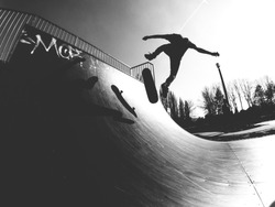 Skater doing kickflip on the ramp - black and white photo