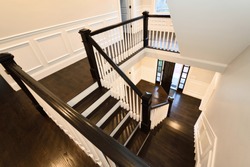 Interior staircase in new home. Colonial style, dark hardwood floor.