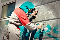 Cleaning graffiti from a building wall