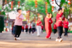 elder Chinese people doing Tai Ji exercise in a park in the morning at blurred focus as background