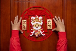 sticking a Chinese New Year of tiger 2022 mascot to the door translation of the Chinese is good luck for the year of tiger