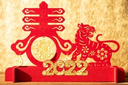 Chinese New Year of tiger 2022 mascot paper cut on a wood table in the morning the Chinese means spring and fortune no logo no trademark
