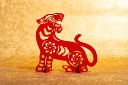 Chinese New Year of tiger 2022 mascot paper cut on a gold background