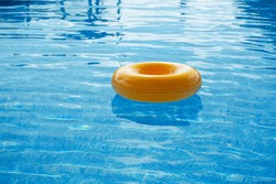 floating ring on blue water swimpool with waves reflecting in the summer sun