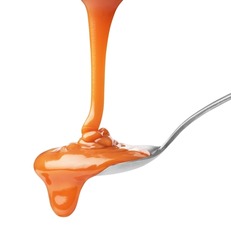 drip of caramel in a spoon on a white background