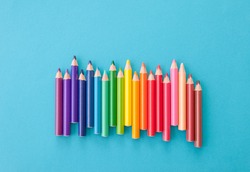 Colorful pens in colors of the rainbow on blue