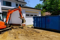 Mini excavator and bobcat on construction site for working in trash container construction dumpsters