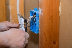 Preparing to remove an electrical outlet of the screws for electrical wires receptacle plug panel