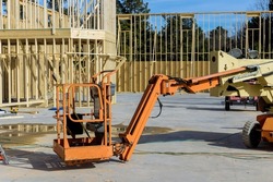 Boom truck forklift in the new home with wood building frame on new residential construction framing beams house installation