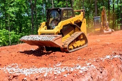 Excavation at a construction site, mini loader bobcat transports crushed stone to different construction places
