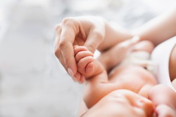 Hand of a newborn baby. Mom holds the baby by the hand. Healthy baby, hospital and happy motherhood concept. Healthy and medical concept. Happy pregnancy and childbirth. Children's theme. 