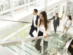 Young business people climb the stairs in the office building