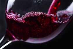  Red wine in wineglass on  black background