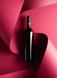 Bottle of red wine on a red background. Top view.