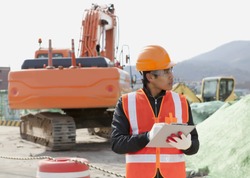 road construction worker and heavy equipment on the background