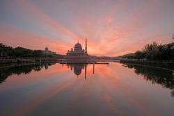 Beautiful red sky during sunrise with lake reflection at Putrajaya Lake Garden.  Motion Blur, Soft Focus due to Slow Shutter Speed. Copy Space Area.