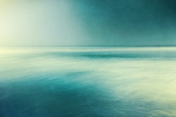 An abstract ocean seascape with blurred panning motion.  Image displays a retro, vintage look with cross-processed colors and a pleasing paper grain and texture.