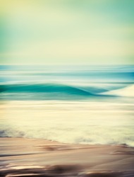 An abstract seascape with blurred panning motion combined with a long exposure.  Image displays a retro look with cross-processed colors.  There's a very fine grain texture visible at 100 percent.