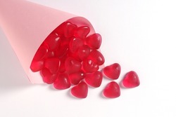 Heart shaped jelly candies in a paper bag on a white background