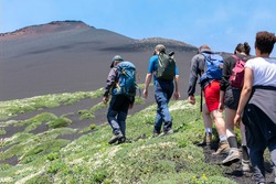 Hikers moving on the land of the Etna volcano in Sicily, Italy.