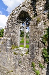 Ancient carved stone window frame in the wall of the ruins of Strade Abbey, County Mayo, Republic of Ireland