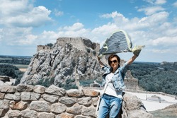Beautiful woman with fluttering scarf on Devin castle. Slovakia, central Europe. Teal and orange photo filter.