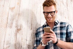 Delighted smiling man using cellphone