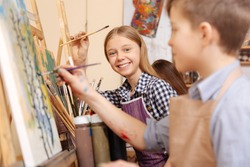 Joyful kids painting in the art school