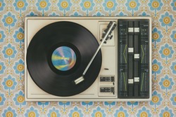 Retro styled image of an old record player on top of flower wallpaper