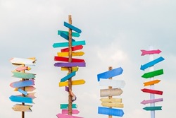 Colorful wooden direction arrow signs on wooden poles