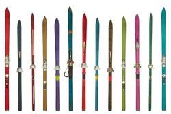 Row of vintage weathered colorful skis isolated on a white background
