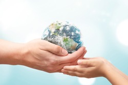 Man gives the Earth globe to the child. World environment day concept. Elements of this image furnished by NASA