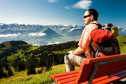 Young man taking rest on the top of the Rigi mountain in Swiss Alps, Central Switzerland