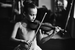 Little girl in tutu playing the violin