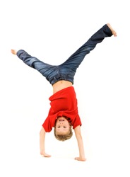 Playful lad standing on his arms with legs pointing upwards over white background