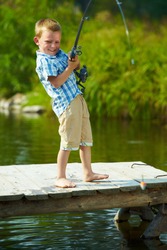 Photo of little kid pulling rod while fishing on weekend