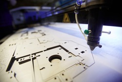 Laser engraving machine cutting details from plywood sheet
