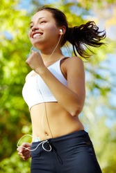 Portrait of a young woman jogging with a walkman