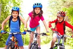 Portrait of three little cyclists riding their bikes