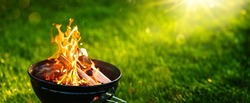Barbecue Grill with Open Fire on Green Grass Background. Fire Flame