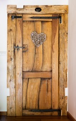 Rustic wooden door with hammered iron reinforcement, heart shaped ornament, private