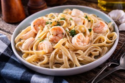 A plate of delicious shrimp alfredo with garlic and cream sauce over pasta.