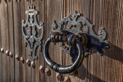 Detail of an antique door handle made of iron with the background out of focus for the copy-space