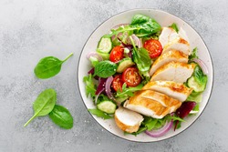 Grilled chicken breast, fillet and fresh vegetable salad of lettuce, arugula, spinach, cucumber and tomato. Healthy lunch menu. Diet food. Top view